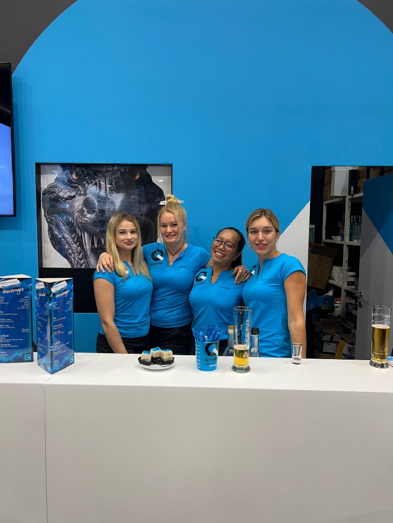 Messehostessen Dortmund im Einsatz zeigen auf Sedcard authentische Portraits mit freundlichem Lächeln am Messestand.